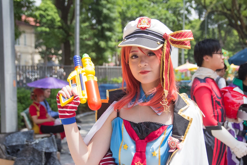 Asian woman in cosplay outfit with water gun in sunny outdoor setting.