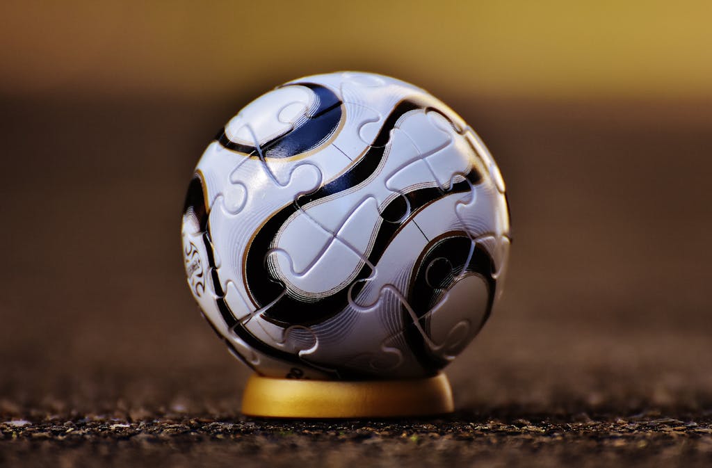 Macro shot of a soccer-themed puzzle ball on a stand, showcasing intricate details.
